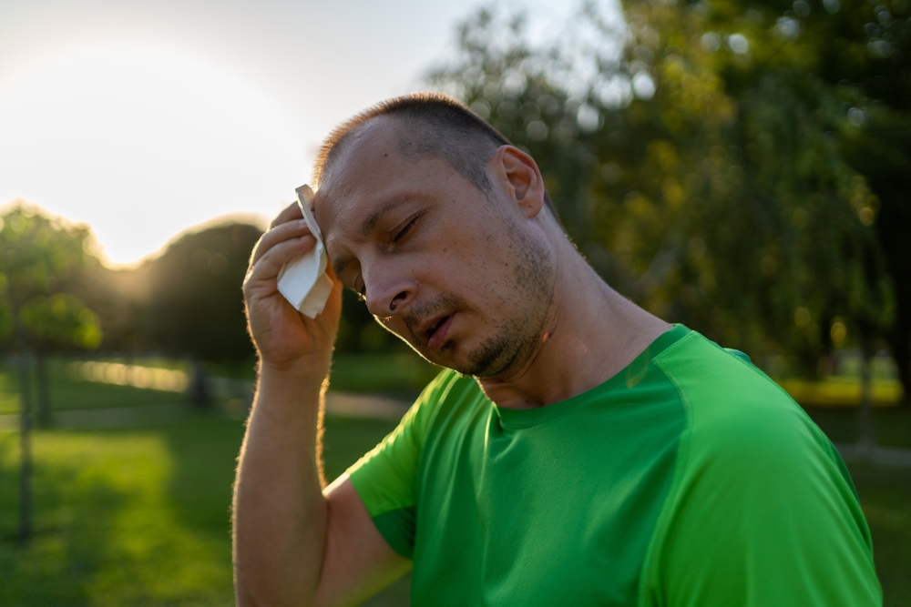 Middle aged man is sweating while exercising.